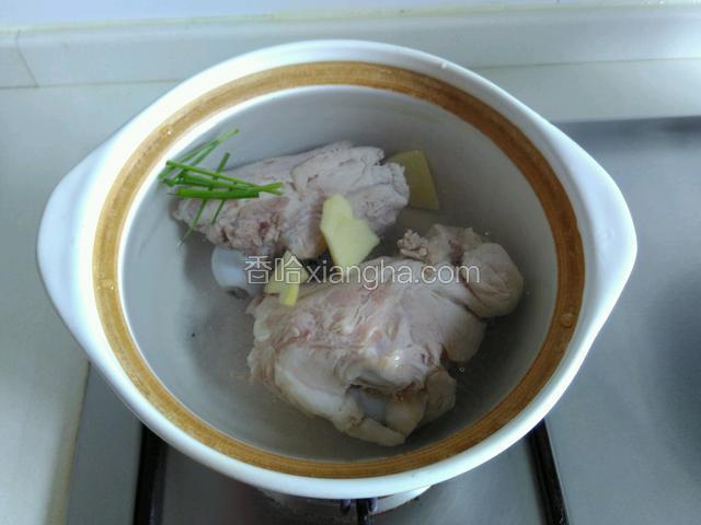 砂锅里放水和筒骨，姜片和葱段，大火烧开