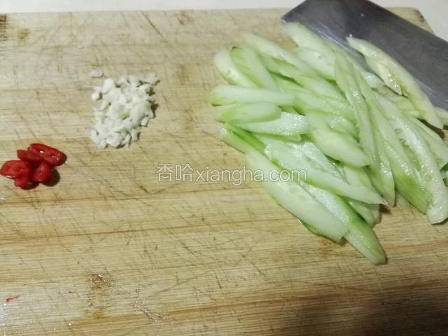 青瓜去皮去籽，切成薄片。蒜头切碎，红辣椒切块。