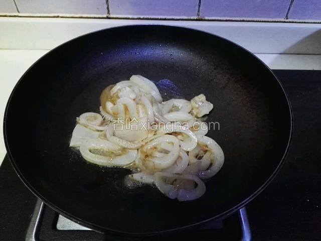 平底锅热入油，油热加入鱿鱼圈，快速翻炒，再改小火。