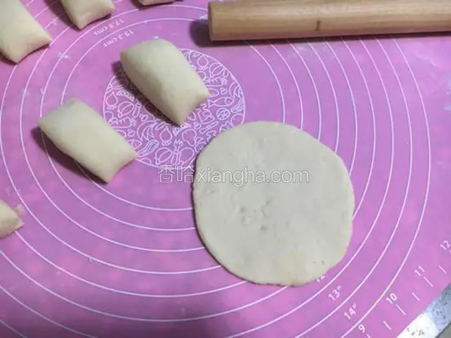 用手压扁，在用擀面杖擀成中间厚四周薄的饼皮