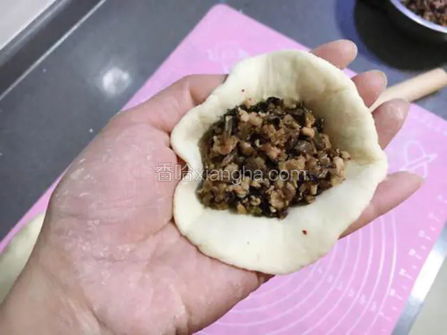 饼皮中间放入适量的馅。