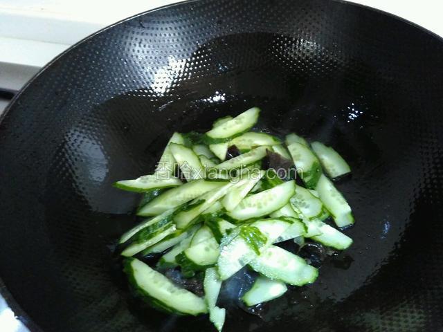 锅里油烧热，倒入黄瓜和木耳，炒匀