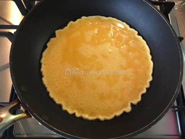 橄榄油热起来了就把蛋液倒入锅中，用勺子整形，成圆形
