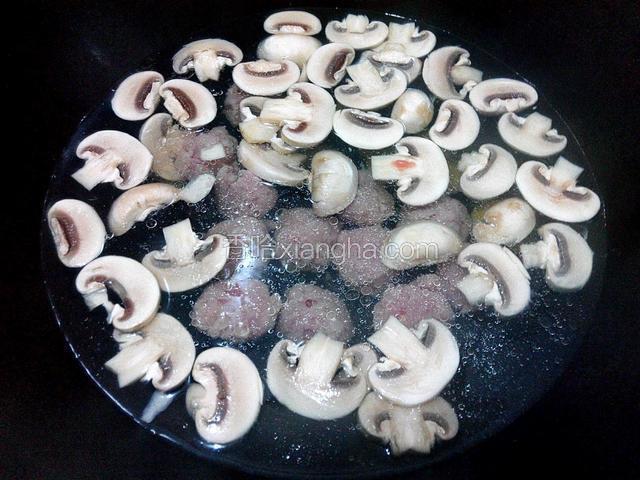 锅里加入适量清水、放姜、大火烧开、放口蘑、肉丸煮五分钟