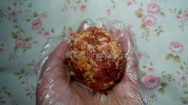 带上一次性手套，将肉丸团成大小适中的丸子。
