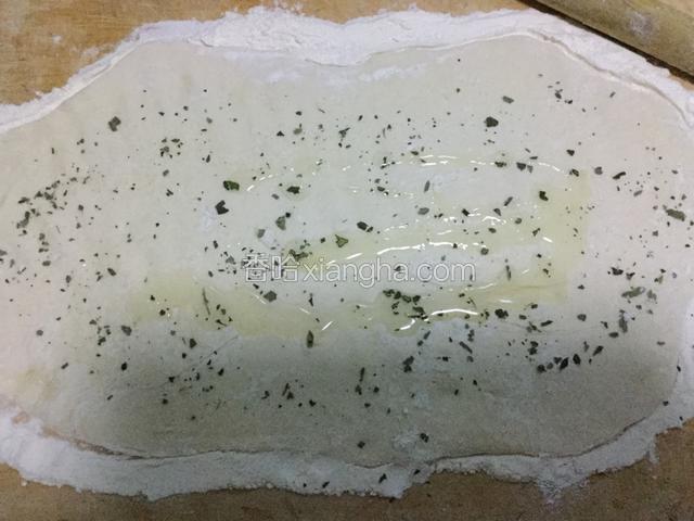 将一小勺食用油均匀倒在面饼上