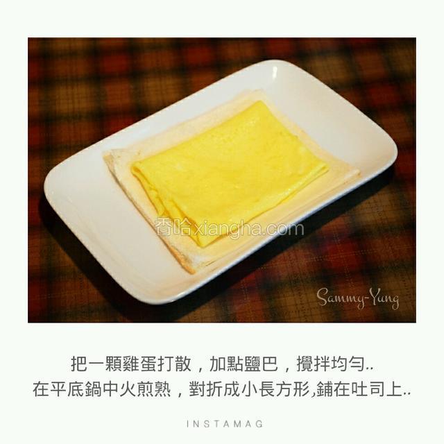 把一顆雞蛋打散，加點鹽巴，攪拌均勻，在平底鍋中火煎熟，對折成小長方形，鋪在吐司上。