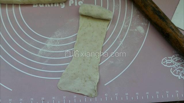 在分个用擀面丈擀开从一边卷实，盖上保鲜膜松驰10分钟