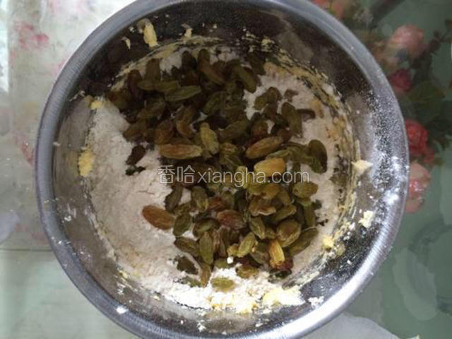 葡萄干控干水，泡打粉和低粉混合均匀后都放入打发好的黄油里