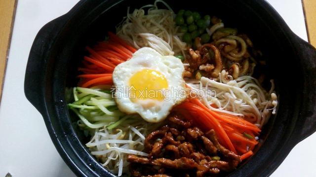 锅底抹层香油，上面铺上米饭，再上面铺上焯好炒好的材料，放上一个煎好单面的荷包蛋。