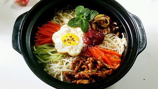 上面洒上白芝麻，蛋黄洒几粒黑芝麻，放上韩式拌饭酱，来个绿叶点缀一下。