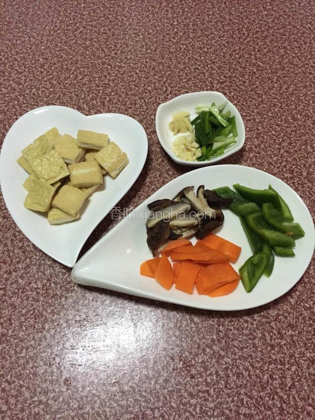 豆腐煎至金黄色，香菇洗净切片，胡萝卜和青椒切片，葱切段，姜切条，蒜头切碎