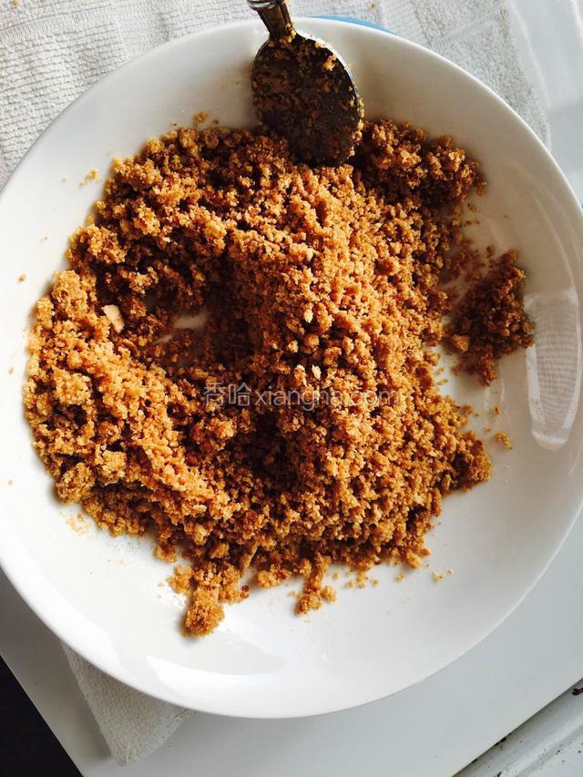 把饼干装入袋子，用擀面杖来回碾碎，把黄油软化后倒入饼干碎搅拌成湿的沙备用