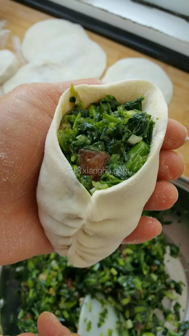 取适量菜馅放入包子皮，两边对捏，成麦穗状。（可以包成自己喜欢的形状）