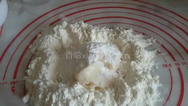 先和水油皮，把低筋面粉倒在面案上扒一个坑，把油和糖粉放进去，我选用的(白油)，你可以选用(黄油，色拉油)。