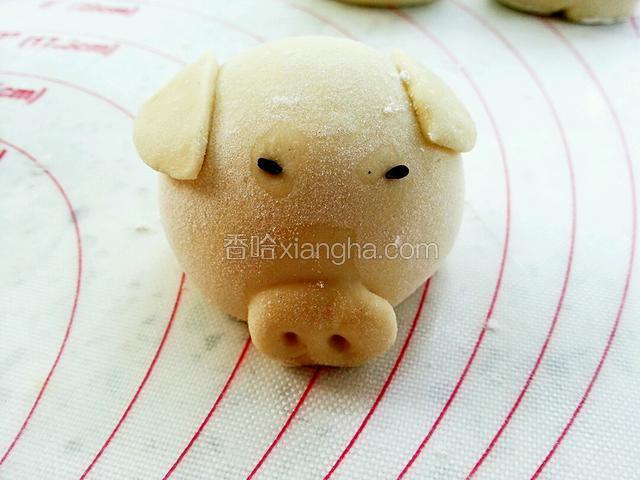 取两粒黑芝麻，沾水粘在猪眼睛部位