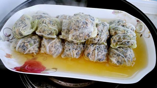 把蒸好的白菜包包用筷子夹至另外盘中，盘中汤汁留作它用。