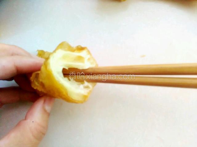 取一个油条用筷子把中间穿过去，肉馅就可以进去了。