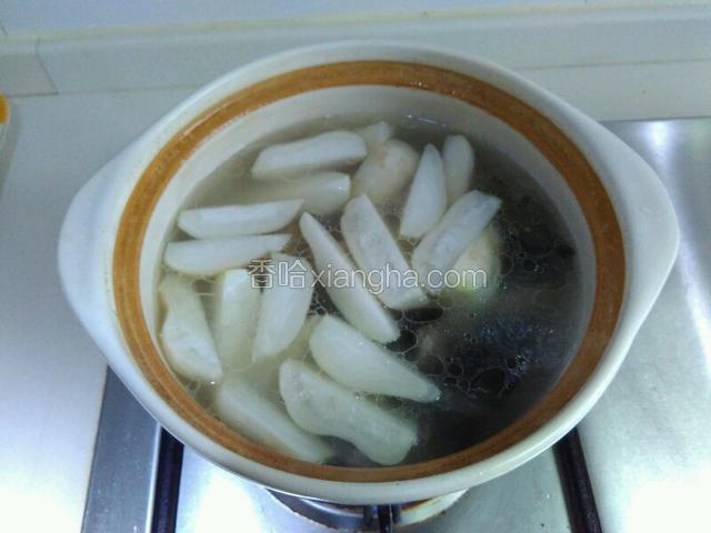 煮到排骨差不多熟烂后，加入萝卜和木耳，加盐大火烧滚后，继续改小火