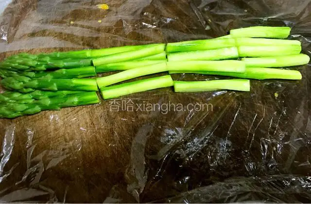 chaos后的芦笋放在铺好保鲜膜的粘板上切成5cm左右的段。