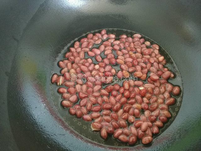 锅中烧油下花生米炒熟，将炒花生米的油浇在葱蒜米椒粒上，爆出香味，花生米倒入，拌匀即可。