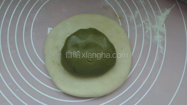 松驰好面团用擀面杖把水油皮擀开，抺茶油面团放上
