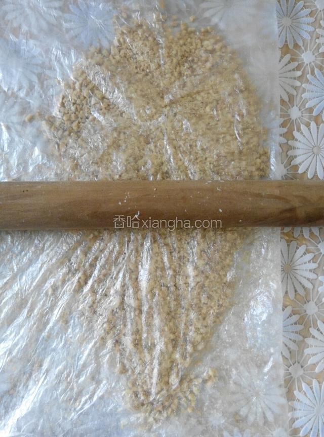 把去皮熟花生仁装入保鲜袋，用擀面杖擀碎！