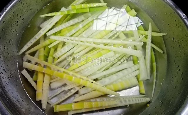 然后捞出过冷水，把笋用刀划成细条