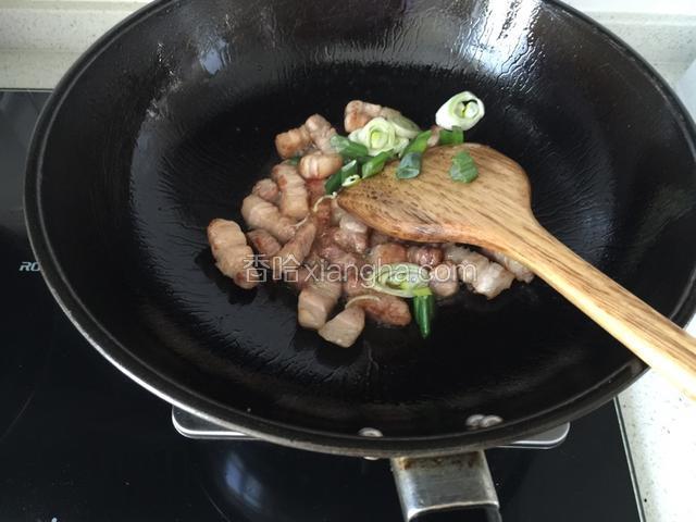 肉丁炒至四周微黄色放入葱花炒出香味。
