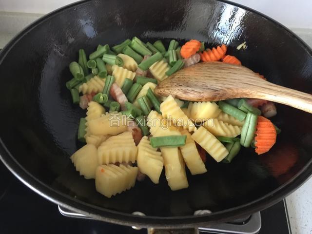 放入豆角等蔬菜继续翻炒。