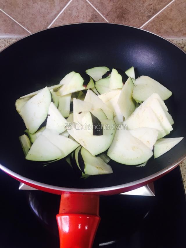 锅中放比平时炒菜稍微多一点点的油，如果平时炒菜就放油多，就照那个标准。

油烧至八成热，放入茄子，中火炒