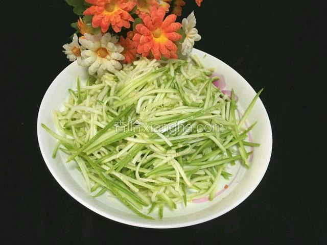 将西葫芦擦成丝儿放入盘子里备用。