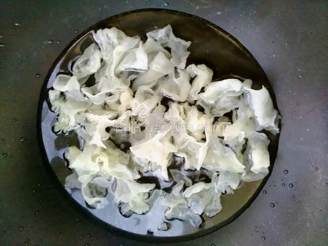把泡好的银耳，去根撕成小朵，用开水略燎一下捞出备用