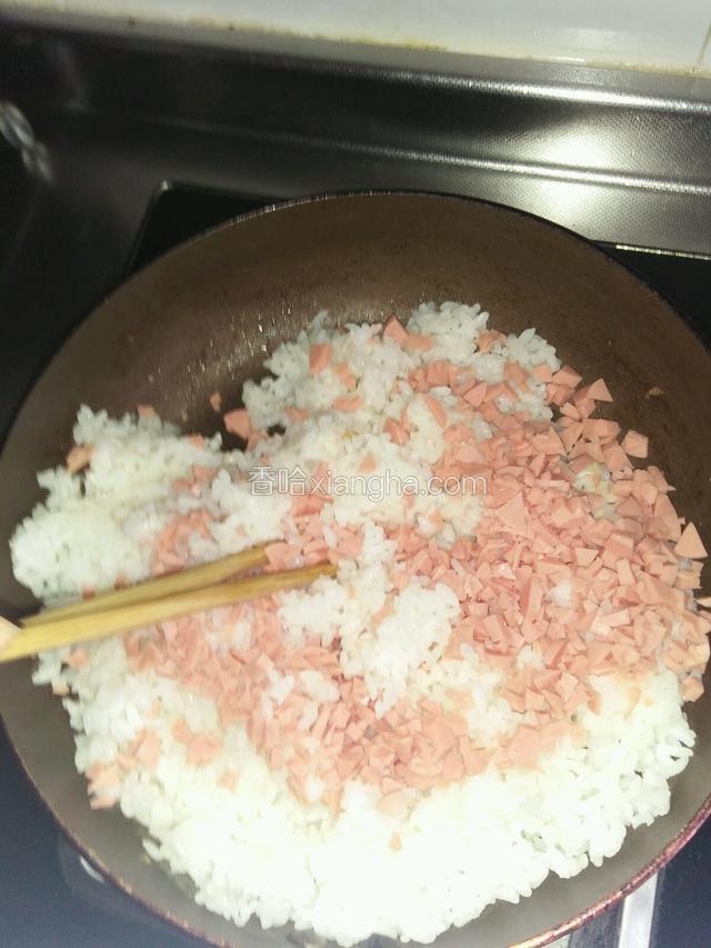 米饭倒入锅里，倒入调好的白醋，火腿肠粒拌均匀。