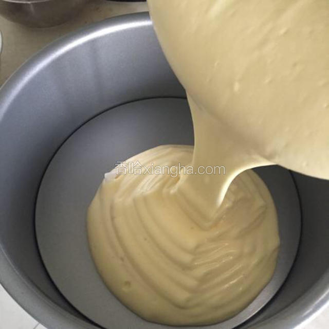 将混合好的蛋糕液缓缓倒入8寸蛋糕模具，成功的蛋液倒入时像绸缎般落下。