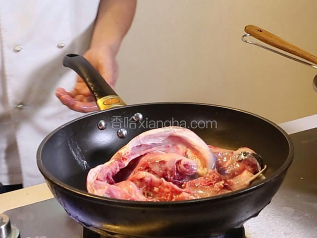 锅中下油20克，油热七成，把鱼头放进去小火煎至两面金黄，捞出备用
