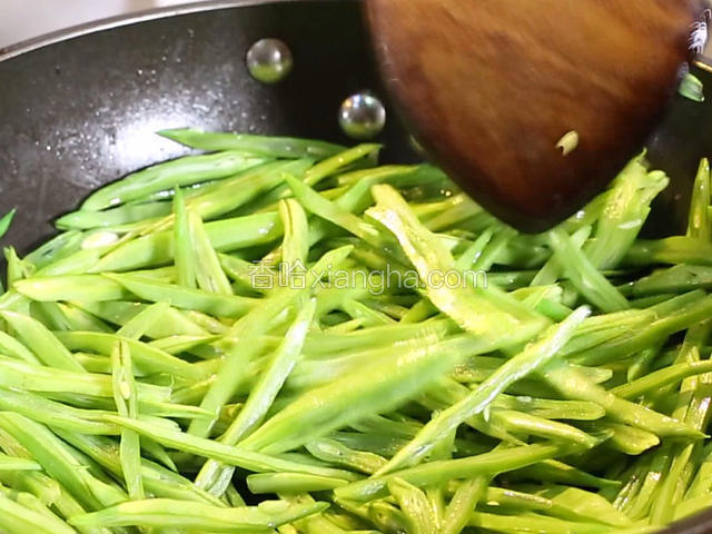 锅中下油10克，大火热油七成，倒入扁豆丝炒至八成熟，加入盐5克，翻炒均匀，倒出备用