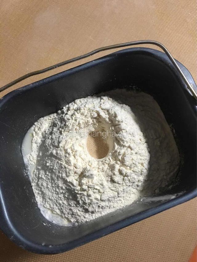 将除黄油以外的所有材料放入面包机桶中，起动面包机揉面程序第一次；