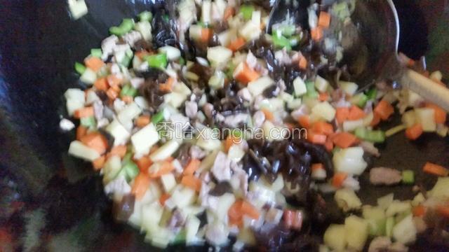 然后放入土豆丁胡萝卜丁尖椒丁，木耳碎翻炒