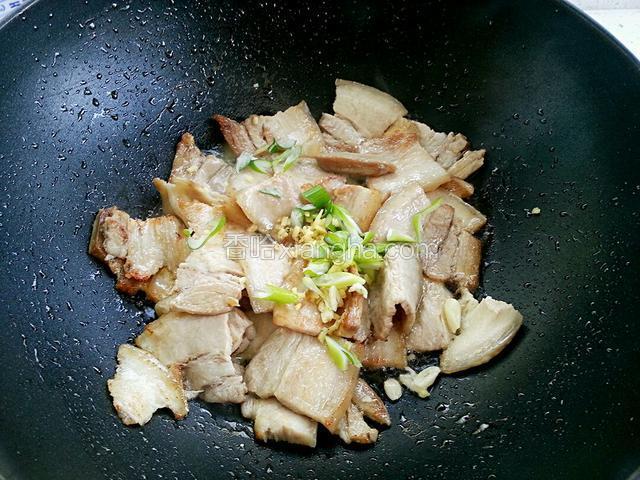 肉片变色锅边淋白酒，放入葱姜蒜翻炒均匀，加一点糖提鲜