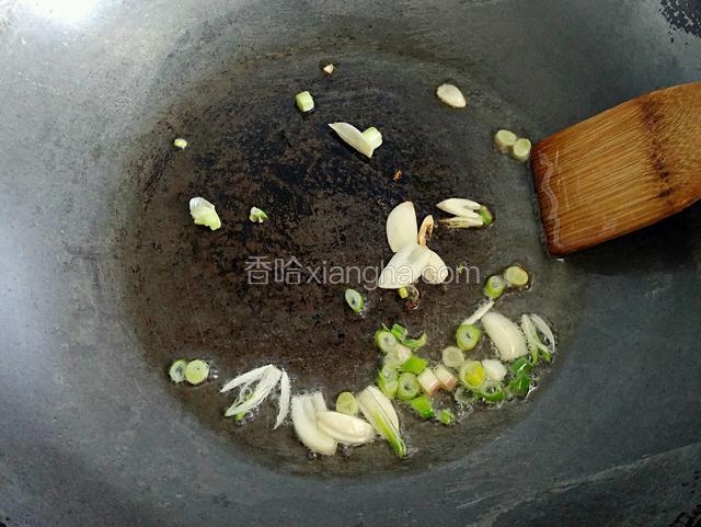 锅内倒少量油，将葱花和蒜片炒香。