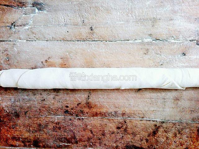 擀好后，用擀面杖把面片卷起来。