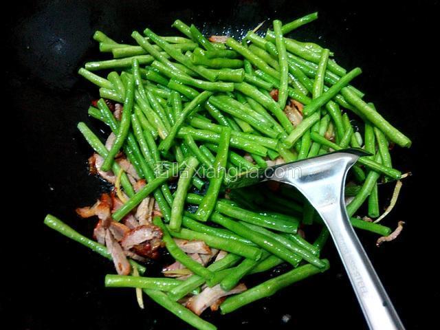 放豇豆翻炒片刻、放盐、放少许酱油、翻炒几下、即可