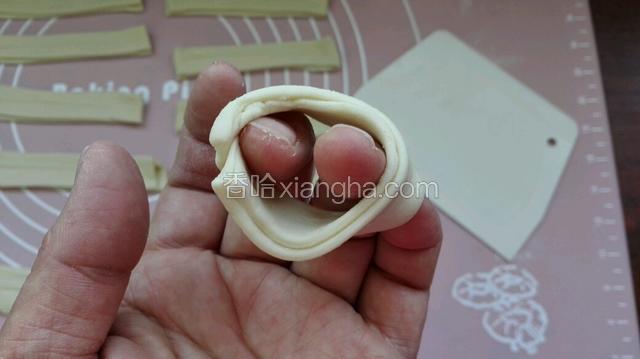 两个面条重叠一起中间轻压一条，然后捏成园圈像这样（尾部捏紧防炸时开开）