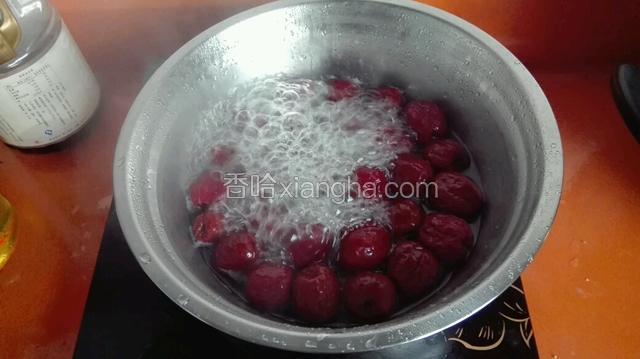 把红枣洗净加入八百克清水放在电磁炉上大火烧开后转小火煮十分钟