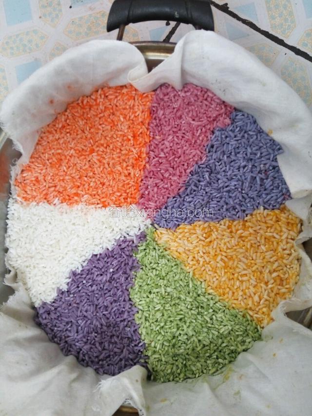 把浸泡好的糯米控干水份待用，锅里放适量水，隔水蒸，把每种颜色的米摆放好！