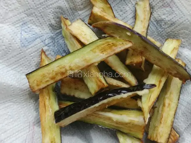 待茄子成熟变色后捞出，用吸油纸吸去茄子表面多余的油。