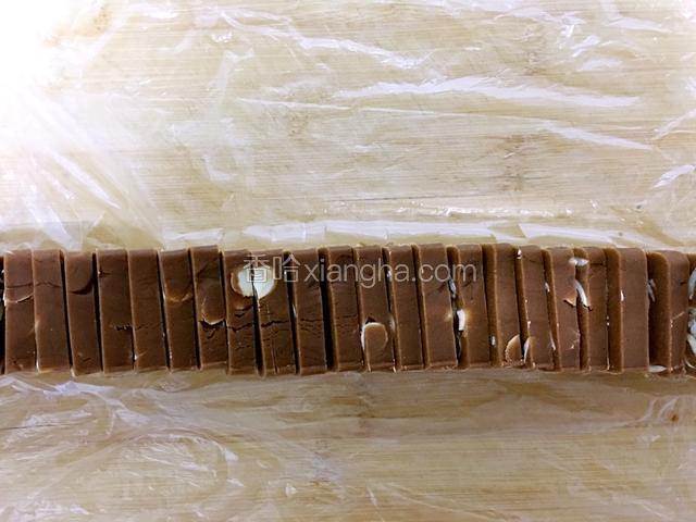 烤箱调成170度预热。之后取出饼干条，切成厚度约0.5-0.6cm的饼干片。放入铺了油纸的烤盘中摆好。继续这个温度上下火烘烤25分钟即可。