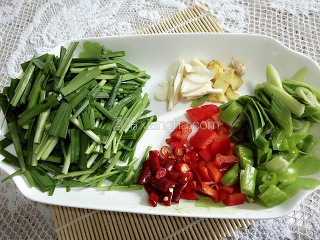 把配料和佐料准备好。韭菜切成3厘米的段，蒜，姜切成片，辣椒切成小段。（如图所示）