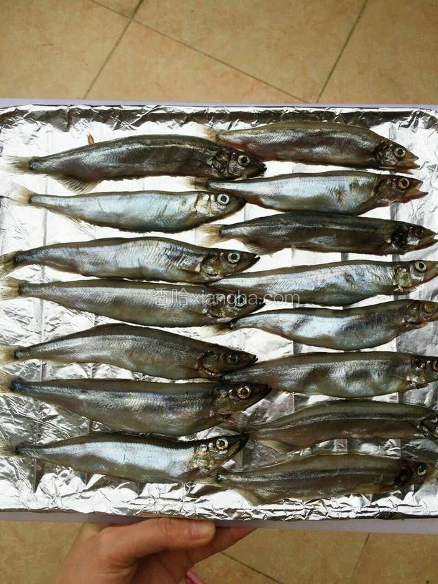 铺上锡纸，刷一层玉米油，把多春鱼摆好